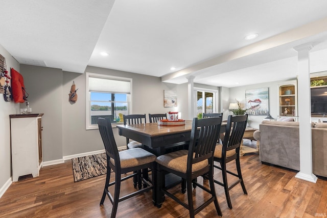 dining room featuring ornate columns, wood finished floors, recessed lighting, baseboards, and healthy amount of natural light