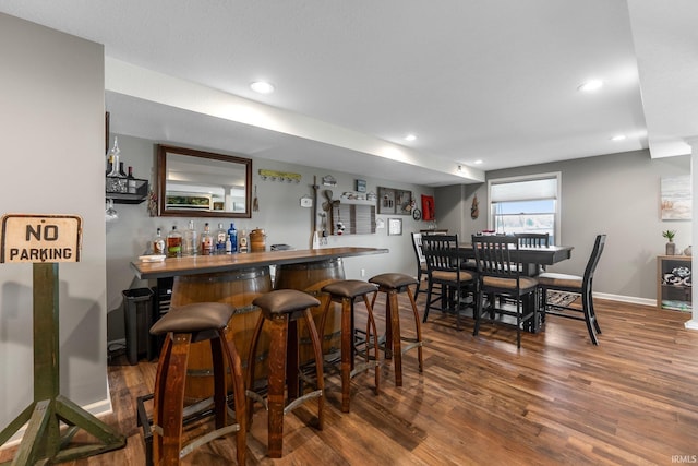 indoor bar with wood finished floors, recessed lighting, and baseboards
