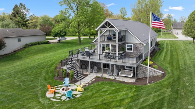 back of property featuring stone siding, a patio area, stairway, a fire pit, and a balcony
