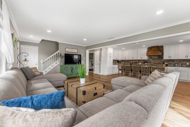 living area featuring ornamental molding, stairway, light wood-type flooring, and recessed lighting