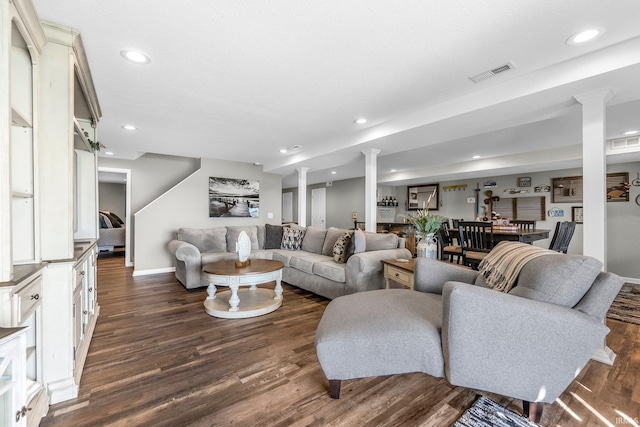 living area featuring dark wood-style flooring, recessed lighting, decorative columns, and baseboards