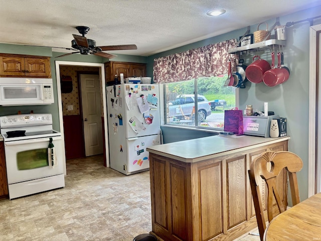 4203 Logansport Rd, Logansport, IN 46947 - kitchen with white appliances, a peninsula, ceiling fan, a textured ceiling, and light countertops