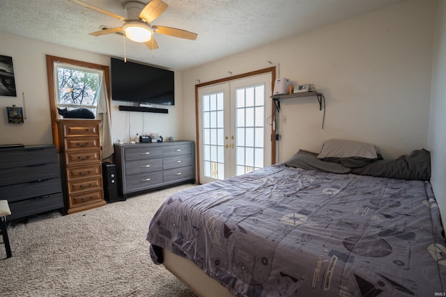 carpeted bedroom with a textured ceiling, french doors, and ceiling fan