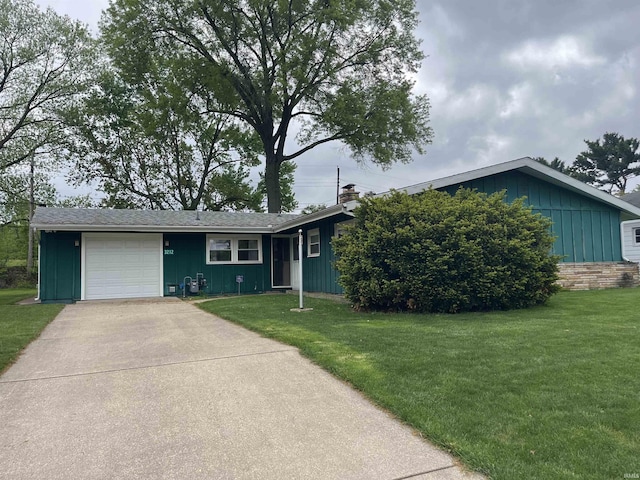 3212 S Saint Joseph St, South Bend, IN 46614 - ranch-style house with board and batten siding, an attached garage, a front yard, and concrete driveway