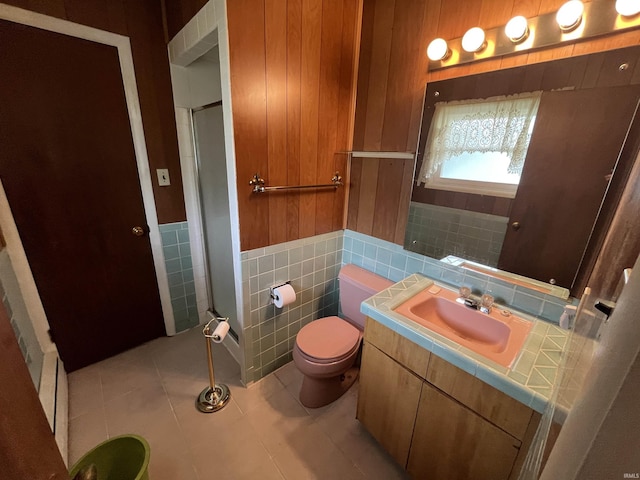 3212 S Saint Joseph St, South Bend, IN 46614 - bathroom with tile walls, an enclosed shower, vanity, tile patterned floors, and toilet