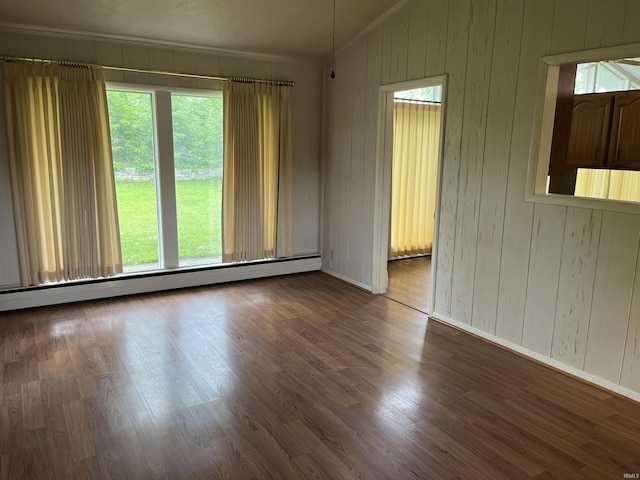 3212 S Saint Joseph St, South Bend, IN 46614 - empty room with vaulted ceiling, baseboard heating, ornamental molding, wood finished floors, and baseboards