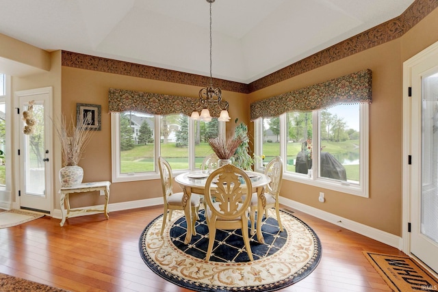 dining room with a chandelier, light wood-type flooring, and baseboards