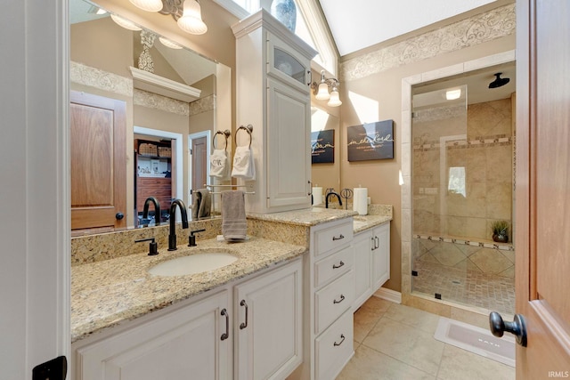full bath featuring a shower stall, two vanities, and tile patterned floors