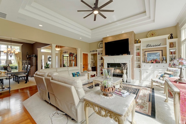 living area featuring a raised ceiling, healthy amount of natural light, a ceiling fan, and recessed lighting