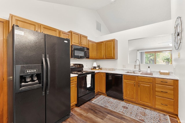 6114 Picacho Dr, Fort Wayne, IN 46825 - kitchen featuring black appliances, dark wood finished floors, a sink, light countertops, and high vaulted ceiling