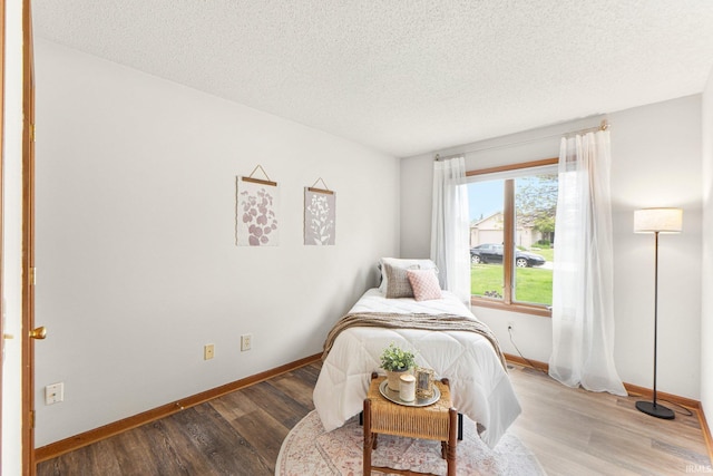 6114 Picacho Dr, Fort Wayne, IN 46825 - bedroom featuring wood finished floors, baseboards, and a textured ceiling