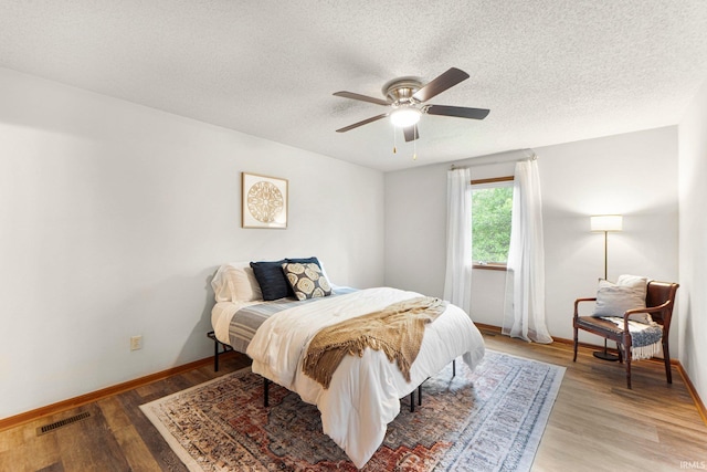 6114 Picacho Dr, Fort Wayne, IN 46825 - bedroom featuring a textured ceiling, light wood-style flooring, baseboards, and a ceiling fan