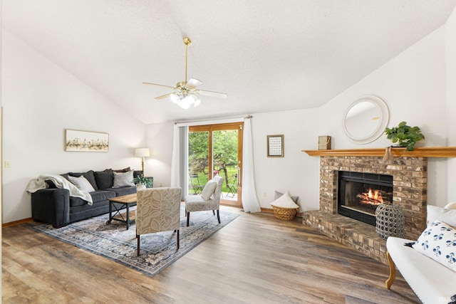 6114 Picacho Dr, Fort Wayne, IN 46825 - living area featuring lofted ceiling, a brick fireplace, ceiling fan, wood finished floors, and a textured ceiling
