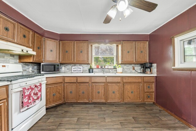 260 N 850 W-92 Rd, Pierceton, IN 46562 - kitchen with white gas stove, under cabinet range hood, stainless steel microwave, and brown cabinets