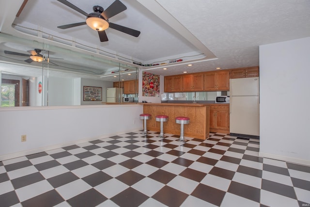 300 Springhaven Dr, Evansville, IN 47710 - kitchen with white appliances, light floors, a tray ceiling, brown cabinetry, and recessed lighting
