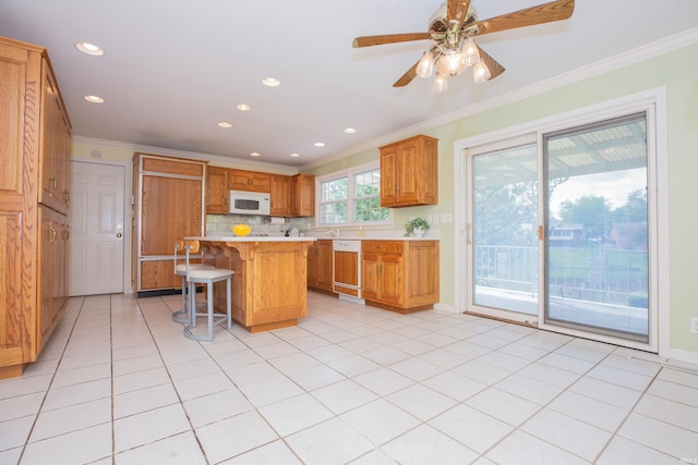 300 Springhaven Dr, Evansville, IN 47710 - kitchen with white microwave, a kitchen bar, light countertops, paneled dishwasher, and tasteful backsplash