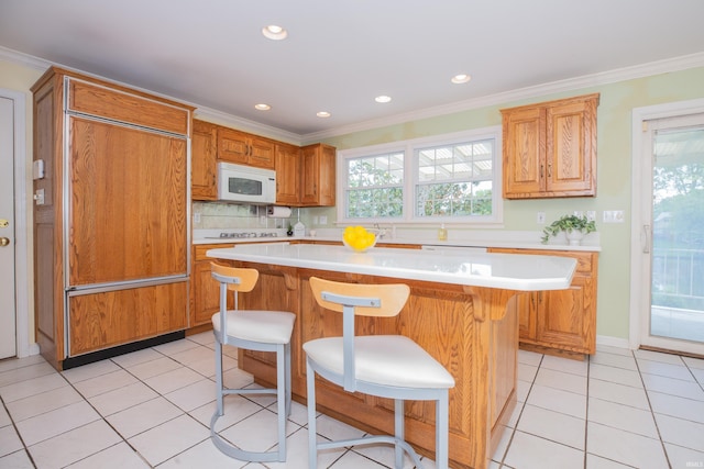 300 Springhaven Dr, Evansville, IN 47710 - kitchen with white microwave, paneled fridge, light countertops, ornamental molding, and a breakfast bar area