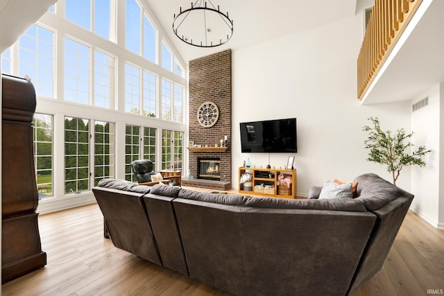 living area with a towering ceiling, wood finished floors, and a fireplace