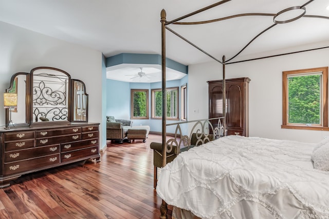 bedroom with dark wood-style flooring and multiple windows