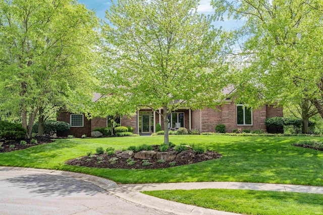 obstructed view of property with a front yard and brick siding