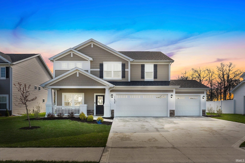 11626 Whistling Trl, Fort Wayne, IN 46818 - view of front facade with driveway, a porch, a shingled roof, stone siding, and a garage