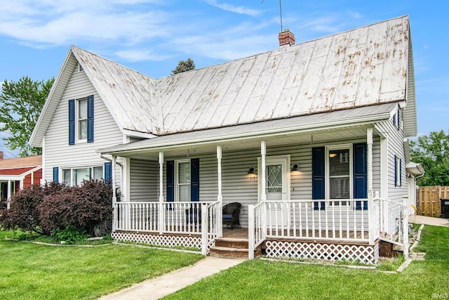 213 E Fourth St, Milford, IN 46542 - view of front of property featuring covered porch, a chimney, a front yard, and metal roof