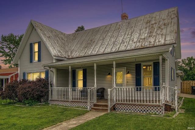 213 E Fourth St, Milford, IN 46542 - view of front of house with a porch, a lawn, and a chimney