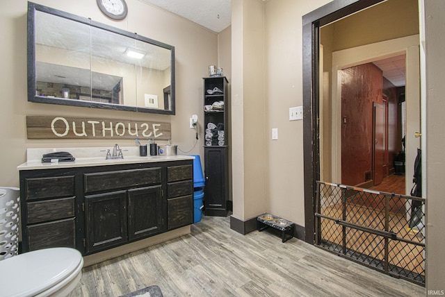 213 E Fourth St, Milford, IN 46542 - bathroom featuring wood finished floors, toilet, vanity, and baseboards