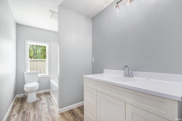 10059 Jefferson Rd, Osceola, IN 46561 - bathroom with wood finished floors, toilet, vanity, a bathtub, and baseboards