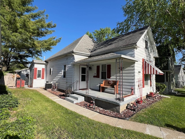 907 S 21st St, Lafayette, IN 47905 - bungalow-style house featuring covered porch, a front lawn, roof with shingles, and central AC unit