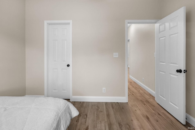 bedroom with wood finished floors and baseboards