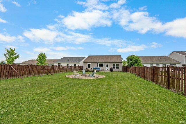 rear view of property featuring a patio and an outdoor fire pit
