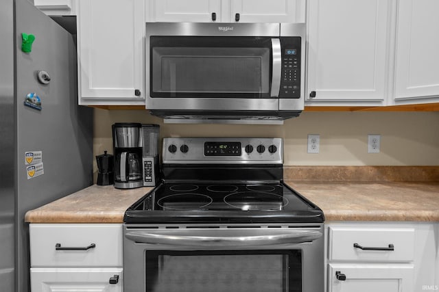 kitchen featuring appliances with stainless steel finishes, white cabinetry, and light countertops