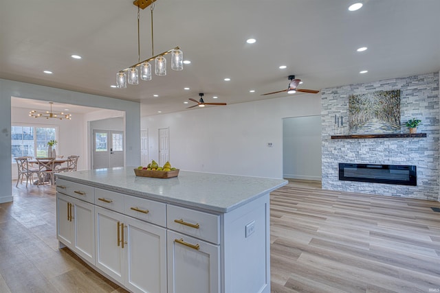 3530 Montgomery Ct, Newburgh, IN 47630 - kitchen featuring open floor plan, ceiling fan, white cabinets, a kitchen island, and light stone countertops