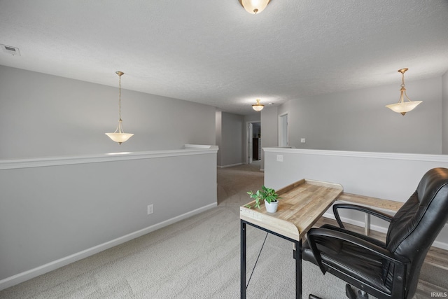 carpeted office featuring baseboards and a textured ceiling