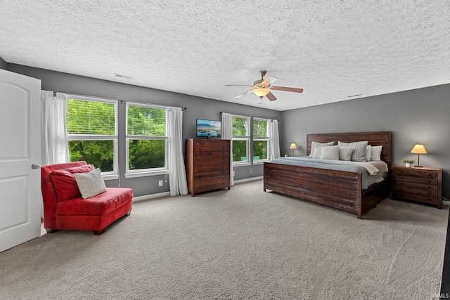 bedroom featuring carpet flooring, ceiling fan, and a textured ceiling