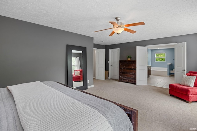 bedroom featuring carpet flooring, a textured ceiling, ceiling fan, baseboards, and connected bathroom