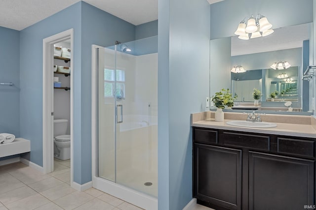 full bath featuring a shower stall, tile patterned floors, toilet, baseboards, and vanity