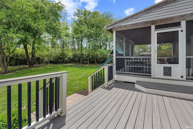 deck with a sunroom and a lawn