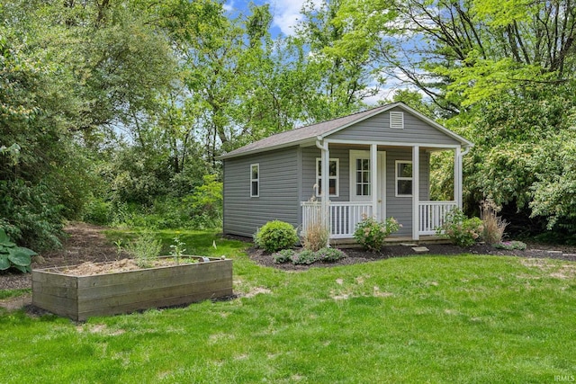 view of outbuilding with a porch and a garden
