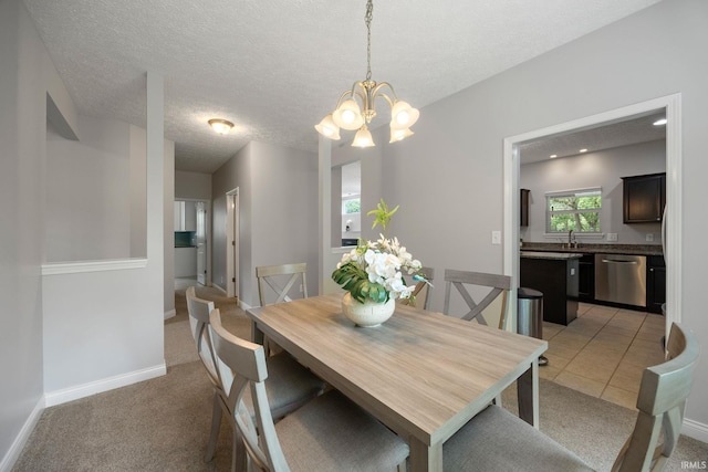 dining space featuring a chandelier, light carpet, baseboards, and a textured ceiling