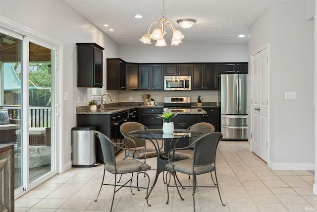 kitchen featuring appliances with stainless steel finishes, a sink, a chandelier, light tile patterned floors, and recessed lighting