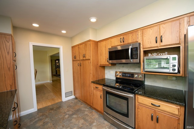 kitchen with appliances with stainless steel finishes, tasteful backsplash, baseboards, recessed lighting, and stone finish floors