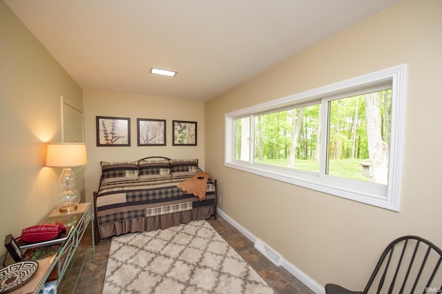 bedroom with dark stone finish floors and baseboards