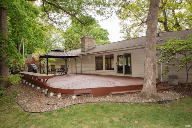 back of property with a gazebo, a chimney, and a wooden deck