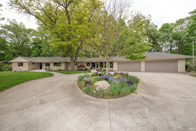 view of front of property featuring concrete driveway, a garage, and a front yard