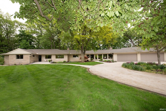 single story home featuring a chimney, driveway, a front yard, and an attached garage