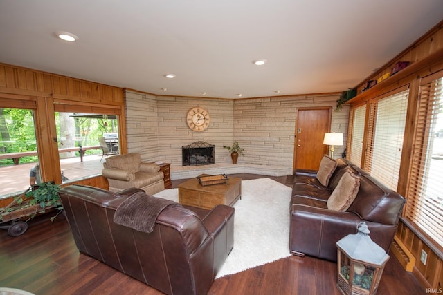 living room featuring a fireplace, wooden walls, wood finished floors, and recessed lighting