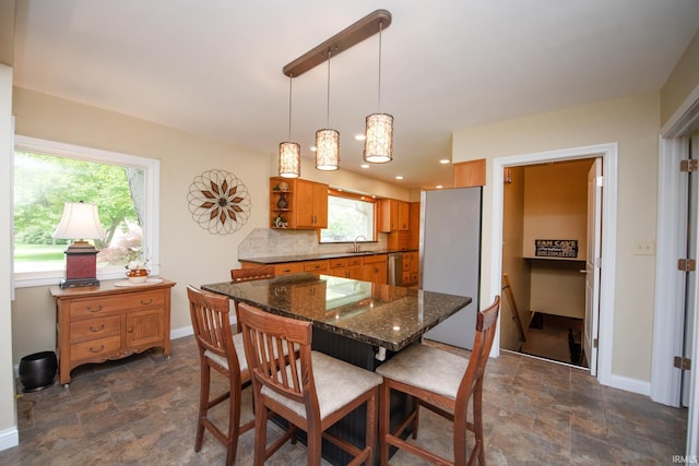 dining area with stone finish floors, baseboards, and recessed lighting