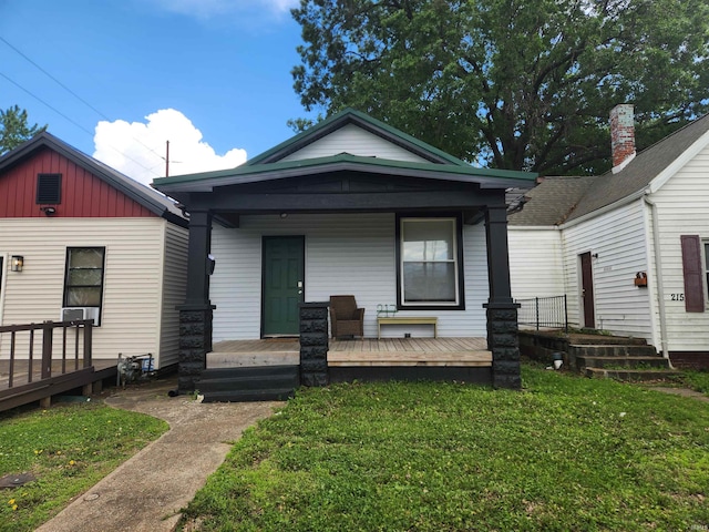 217 E Eichel Ave, Evansville, IN 47711 - shotgun-style home with a front lawn, covered porch, and board and batten siding